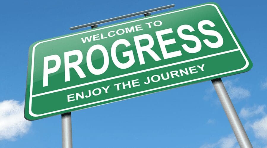 A green sign that says welcome to progress.